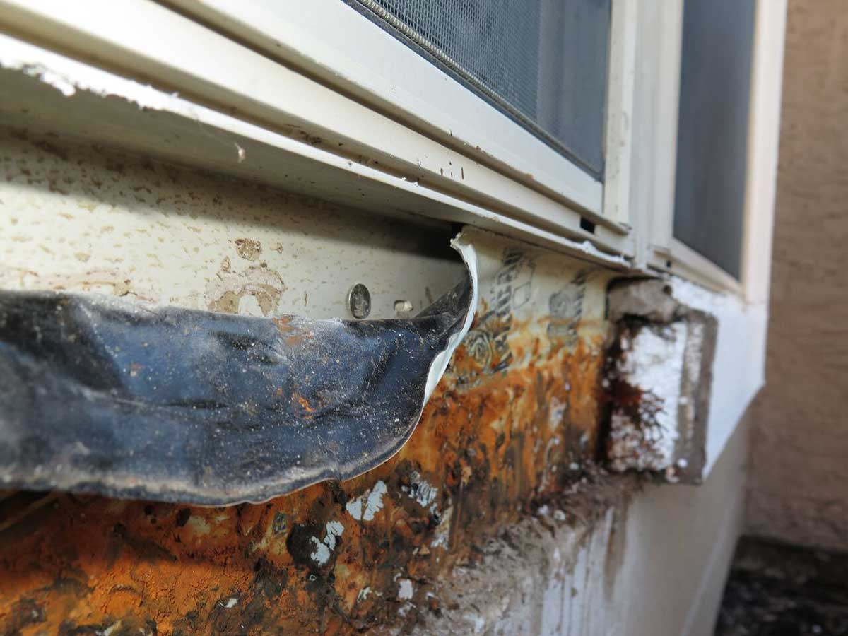 Roof consultants examining rust behind EIFS in Austin, Texas.